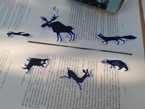Zwierzęta z papieru leżą na książce.