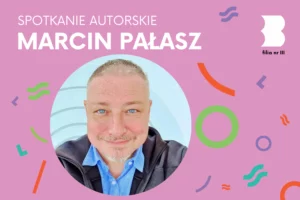 Portret krótko ostrzyżonego mężczyzny z bródką uśmiechającego się do obiektywu.