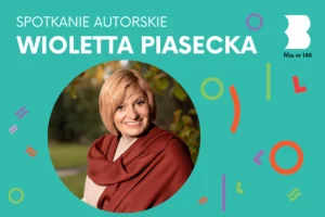 Uśmiechnięta dojrzała blondynka owinięta brązowym szalem stoi na tle zazielenionego parku.