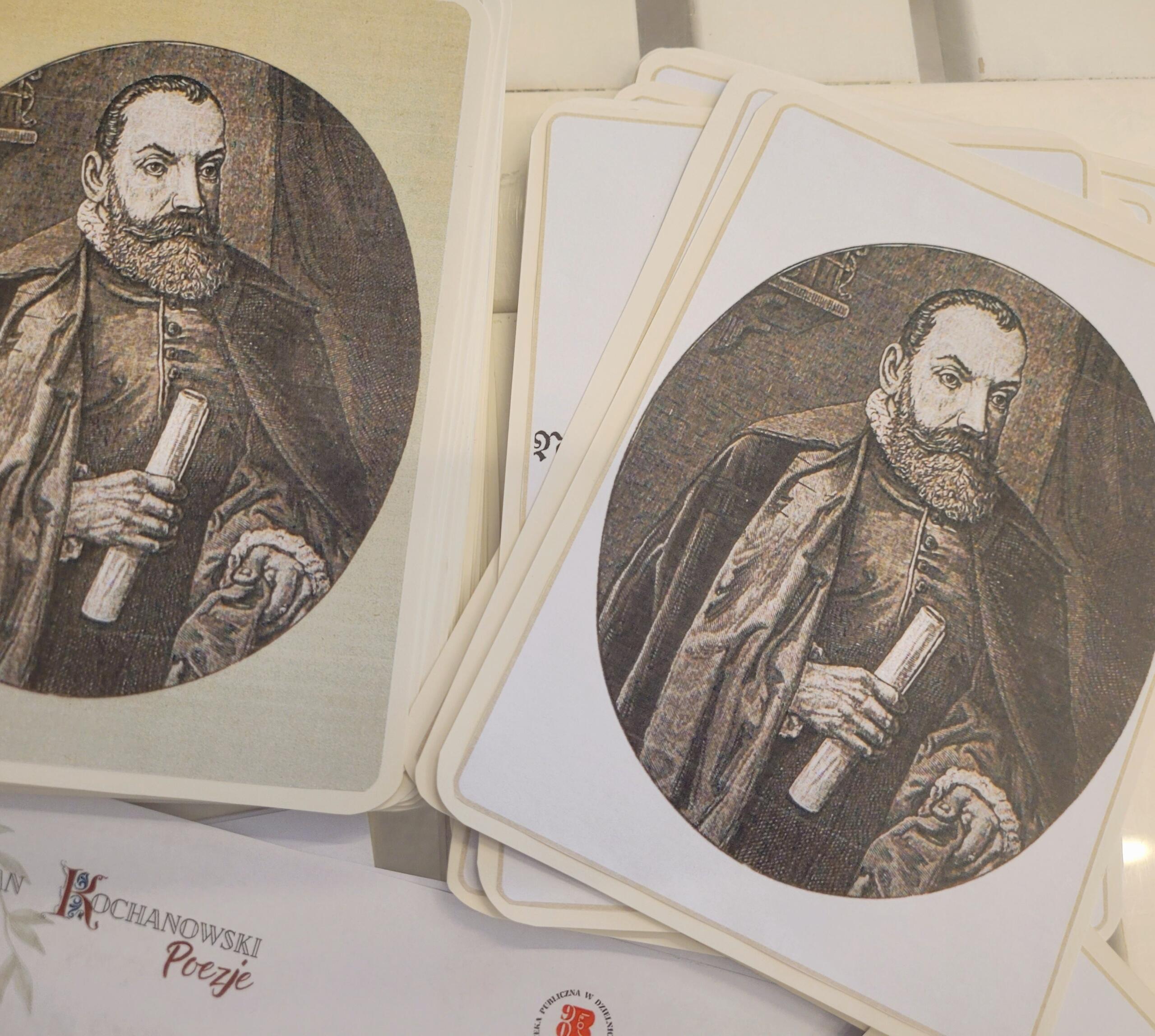 Na obrazku widzimy stos kart przedstawiających Jana Kochanowskiego, na których widnieje portret mężczyzny w historycznym stroju. Mężczyzna posiada brodę i ubrany jest w ciemną szatę z falbaniastym kołnierzem. W prawej dłoni trzyma zwój. Portret ma okrągły kształt i jest utrzymany w sepii, co nadaje mu antyczny charakter. Karty są lekko wachlarzowo rozłożone, ukazując krawędzie kilku z nich.